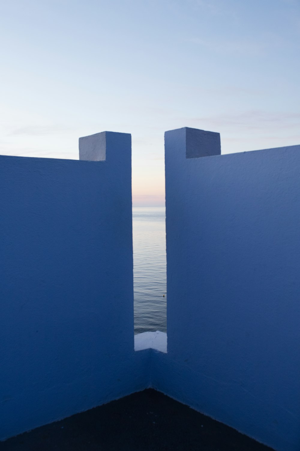 a view of the ocean from a blue wall