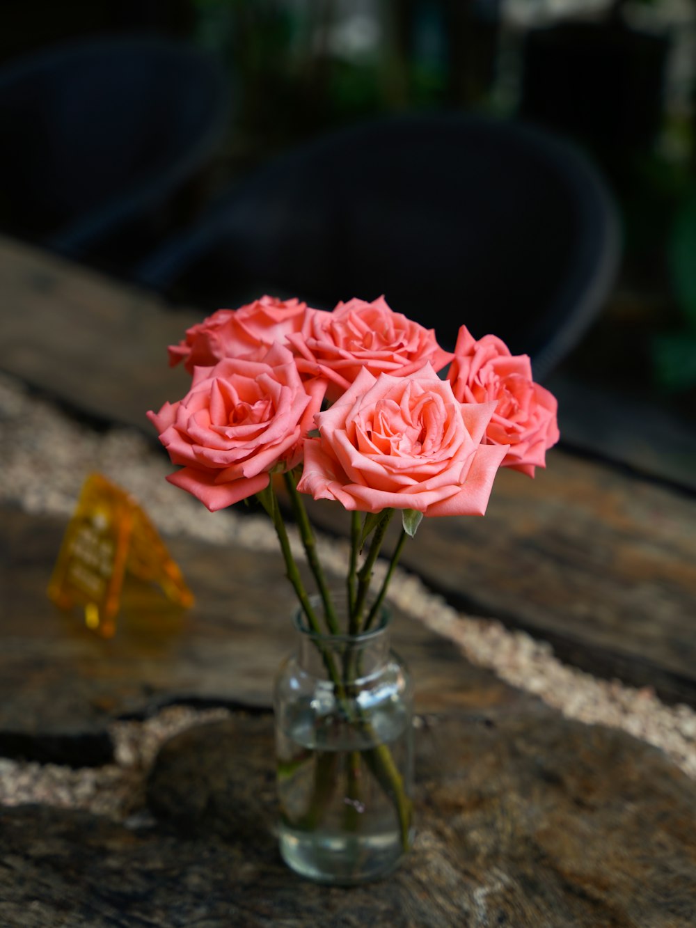 a vase filled with pink roses on top of a wooden table