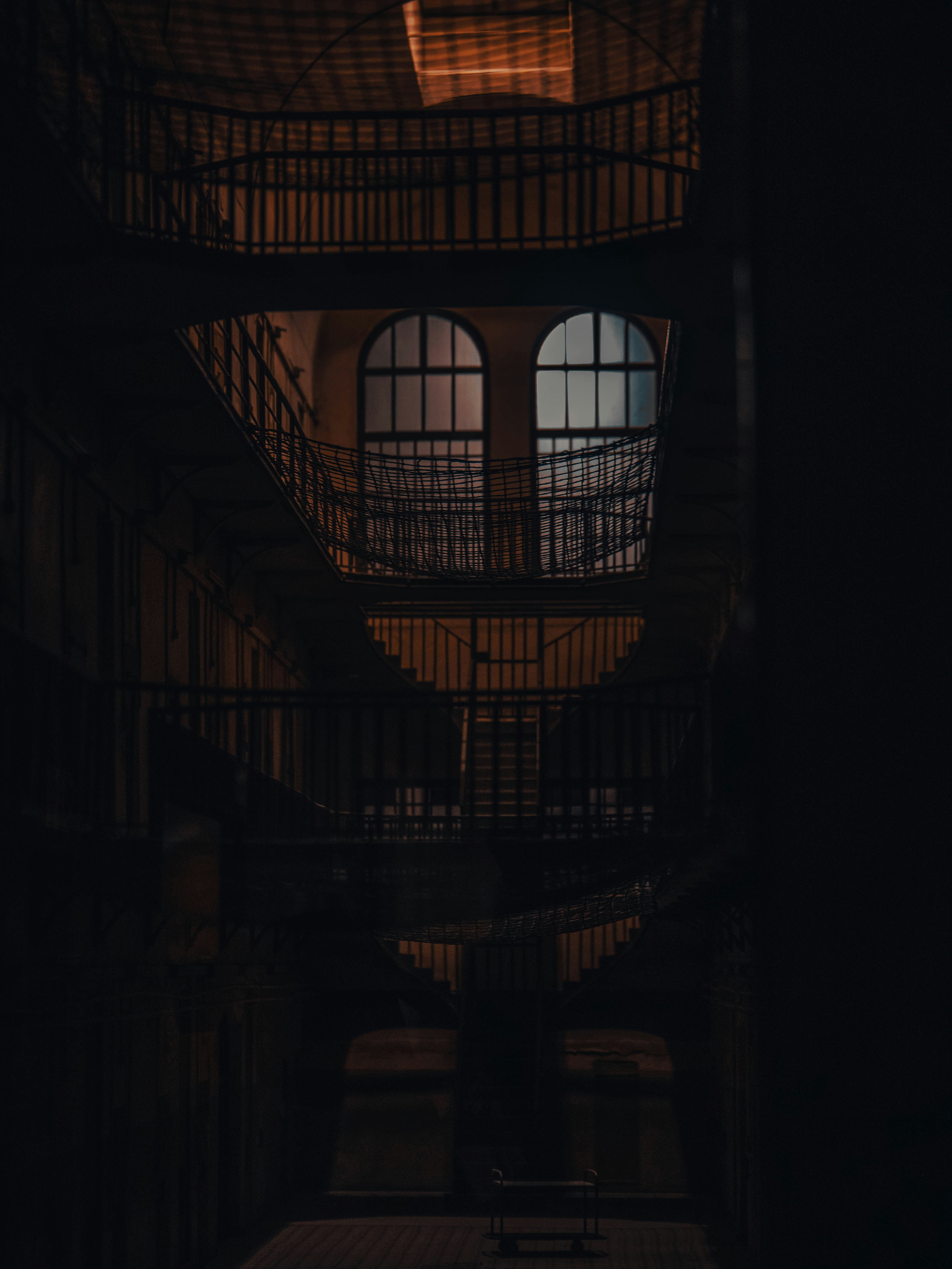 a dark room with a spiral staircase and a window
