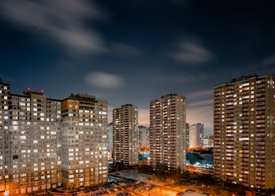 Night view of a high-rise apartment with city lights.