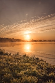 A serene landscape from a recent trip, showing a quiet lake at sunset with soft golden light.