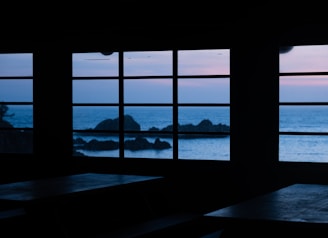 A serene esthetician studio with nautical decor overlooking the Pacific Ocean at sunset.