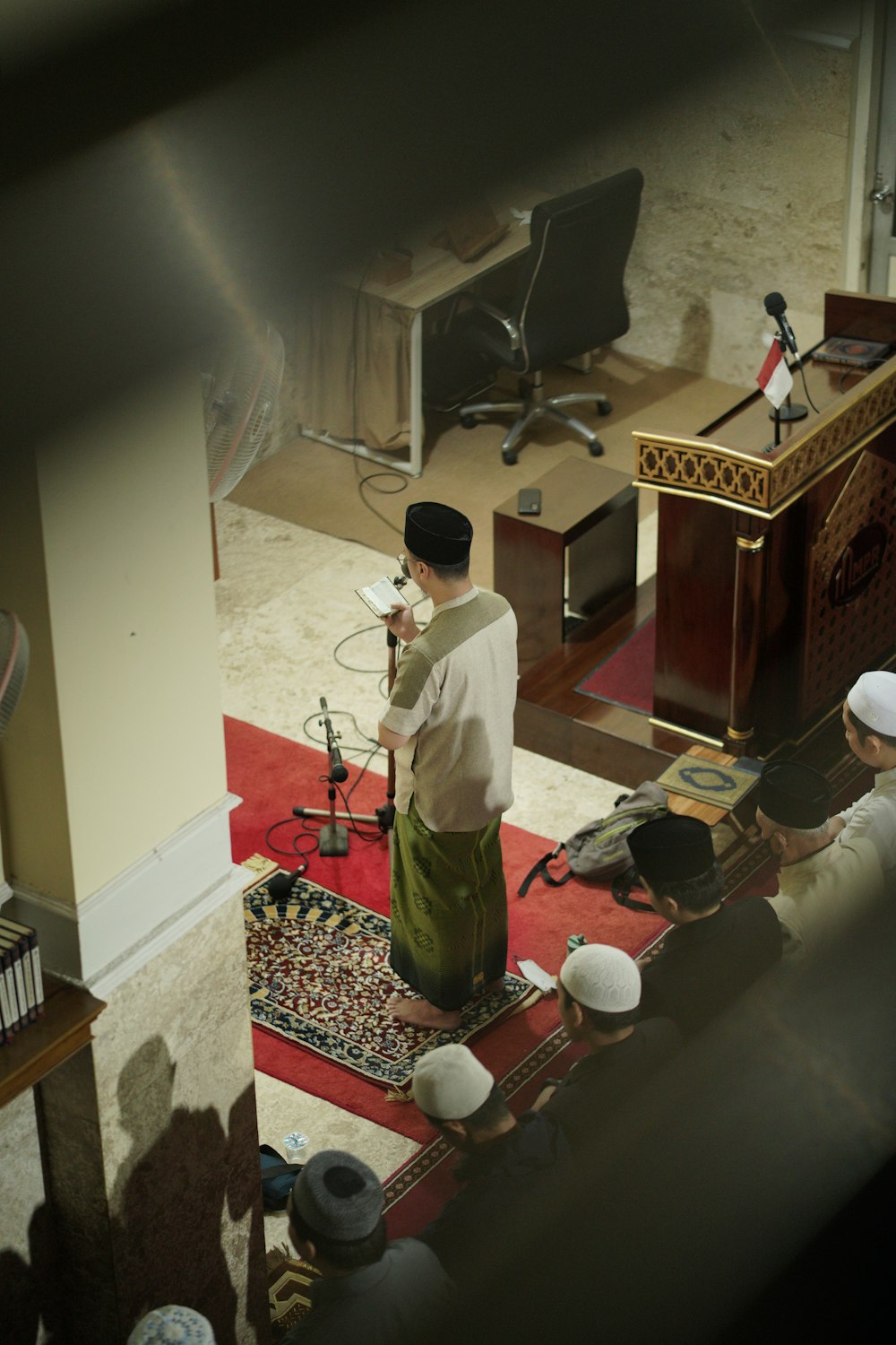 a man standing in a room next to a red rug