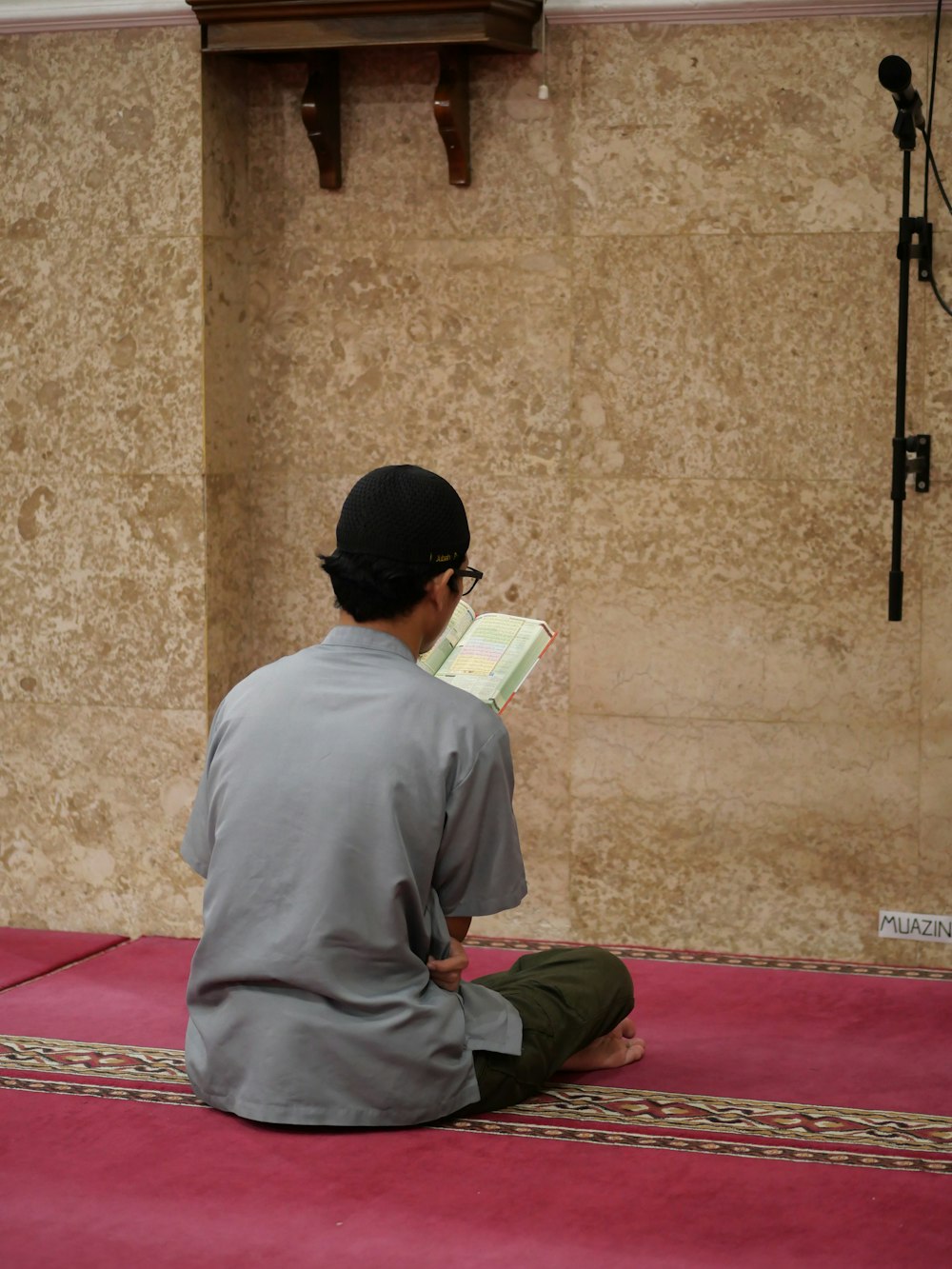 a man sitting on the floor reading a book