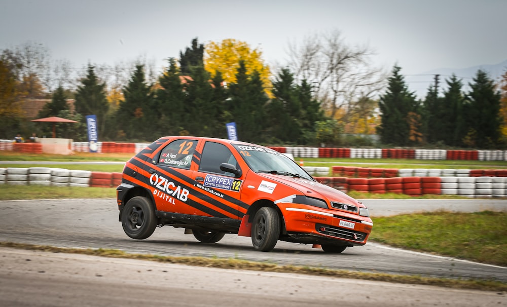 a small orange car driving on a race track