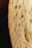 Close-up of golden-brown sourdough with crispy crust torn open to reveal airy interior.
