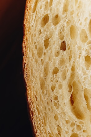 Close-up of a traditional Minas Gerais cheese bread being pulled apart, showing its gooey inside.