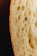 Close-up of golden-brown sourdough with crispy crust torn open to reveal airy interior.