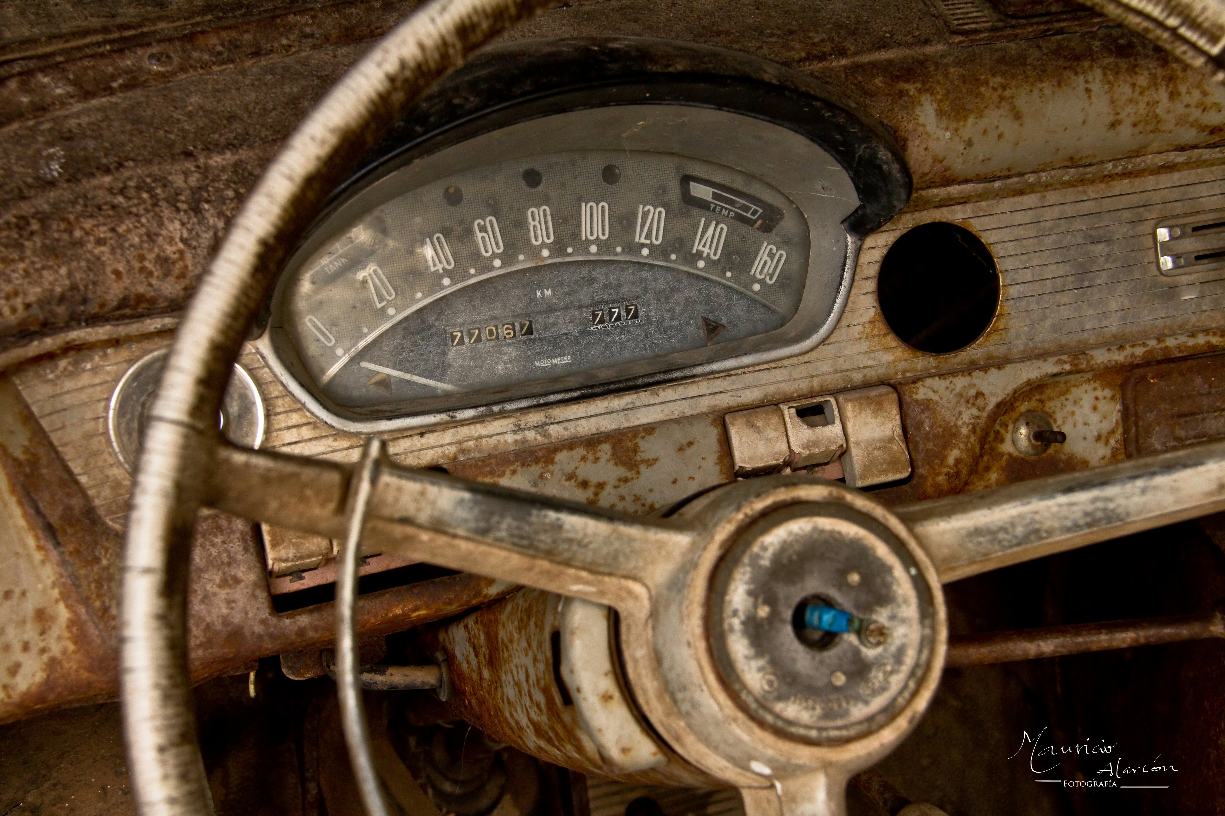 the dashboard of an old car with rust on it