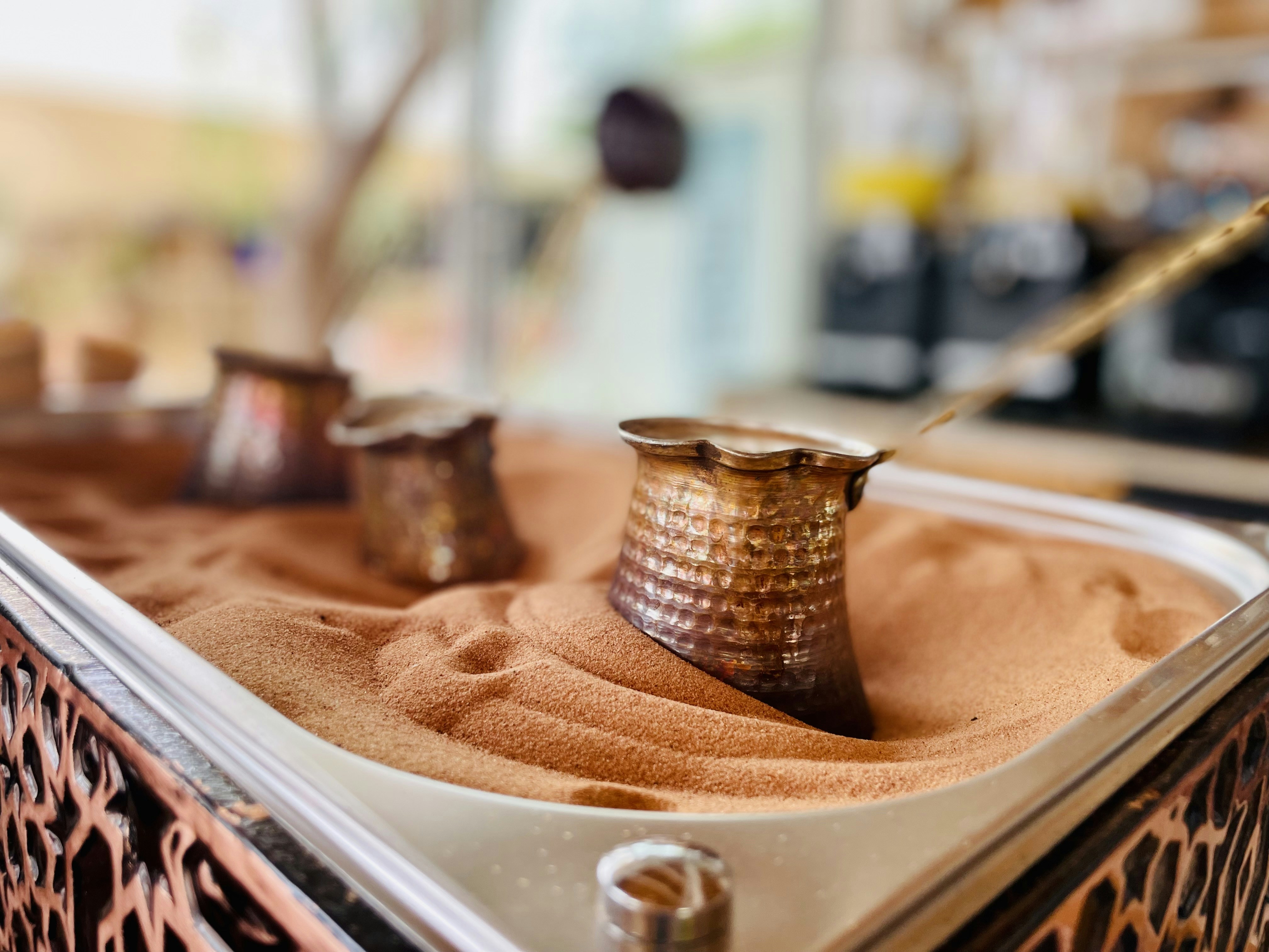 a metal container filled with sand next to a tree, Turkish Coffee