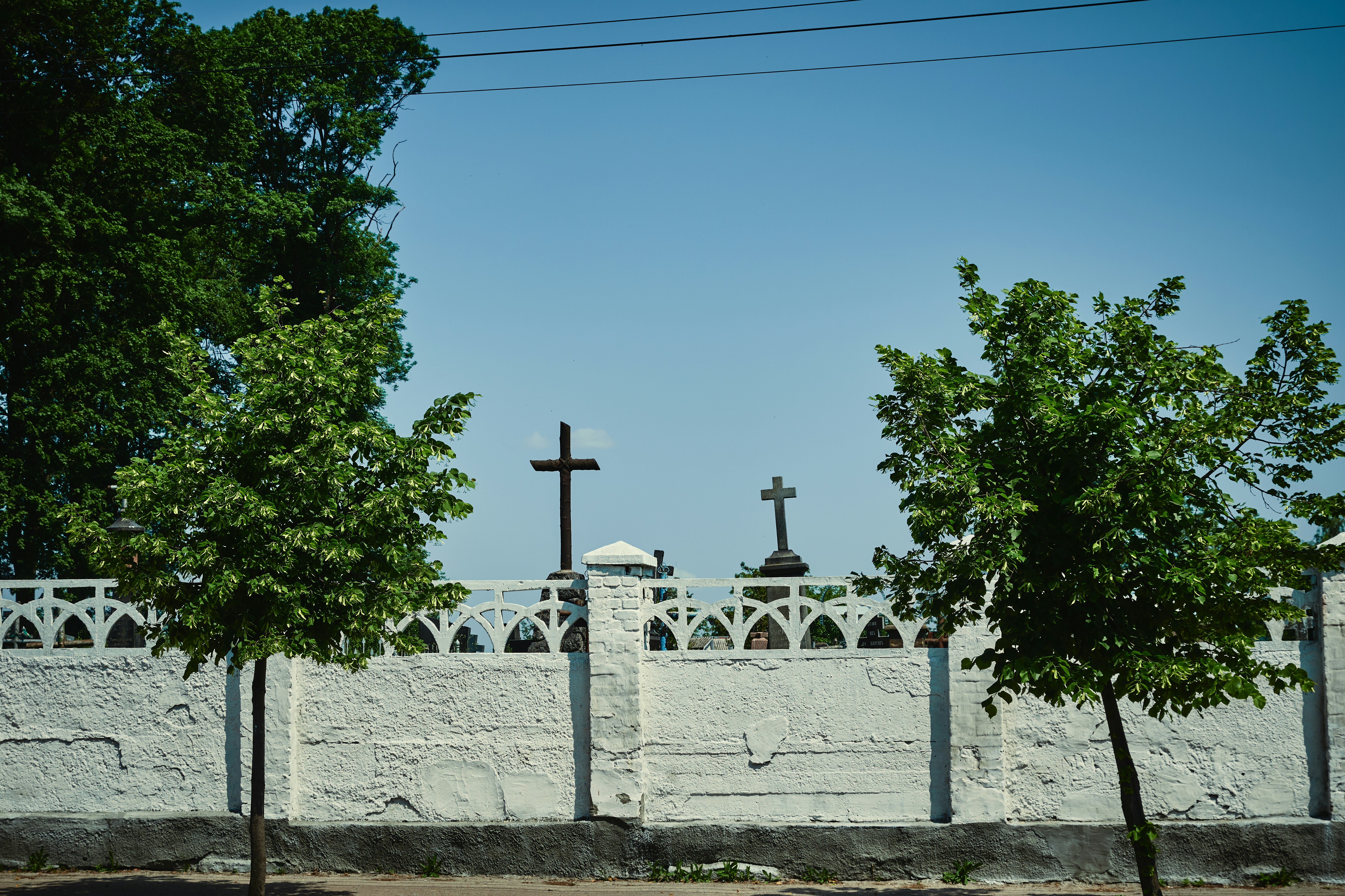 ein weißer Zaun mit einem Kreuz darauf