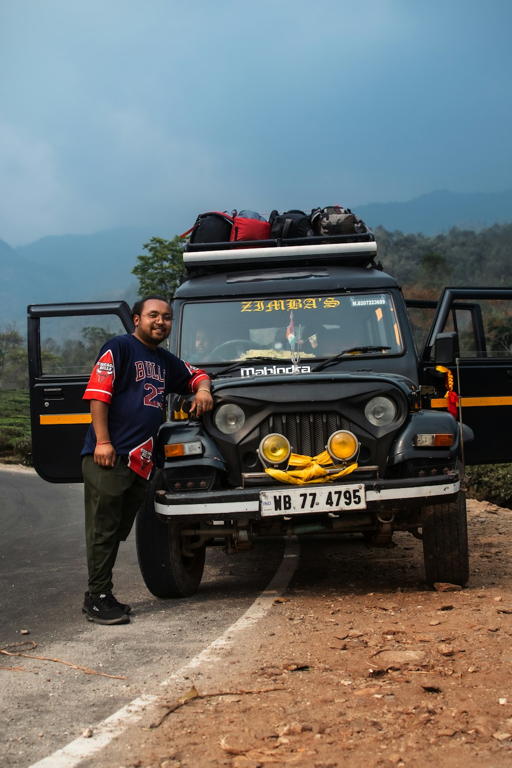 a man standing next to a black jeep