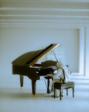 a person sitting at a piano in a room