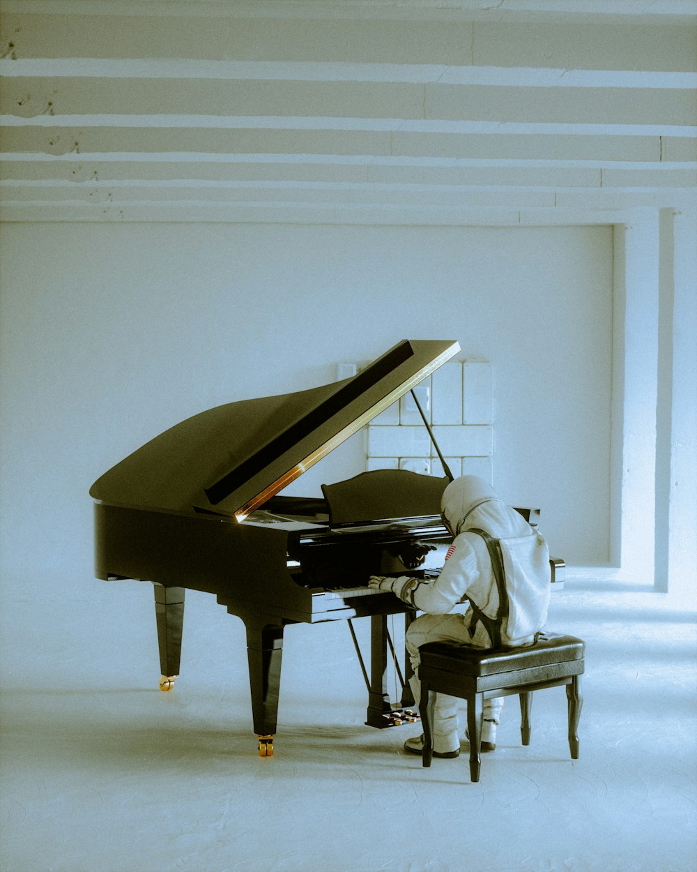 Una persona sentada al piano en una habitación