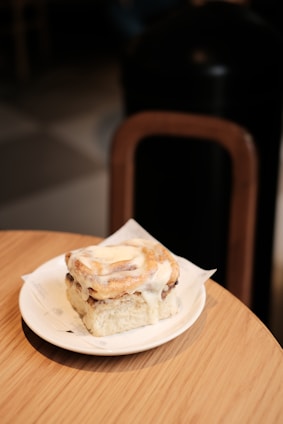 Freshly baked cinnamon rolls with swirls of icing on a cozy kitchen table
