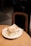A warm, freshly baked cinnamon roll with icing on a rustic wooden table.