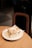 A warm, freshly baked cinnamon roll with icing on a rustic wooden table.