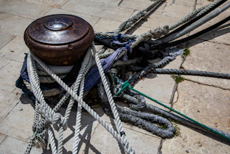 Industrial marine bollard installation on a concrete quay, with thick ropes tightly fastened during vessel docking.