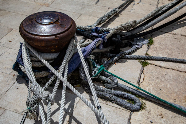 Industrial marine bollard installation on a concrete quay, with thick ropes tightly fastened during vessel docking.