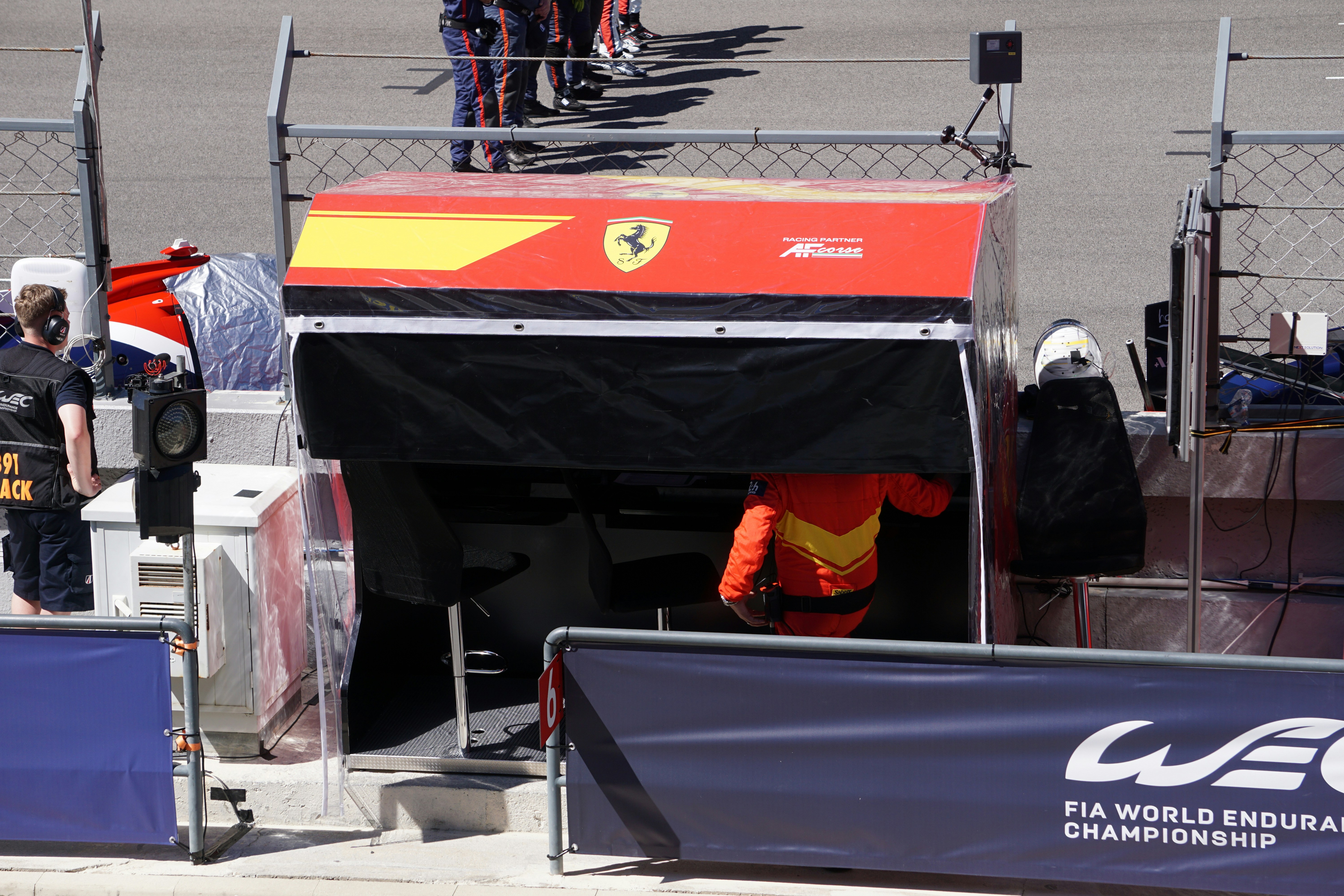 a group of men standing next to each other on top of a race track