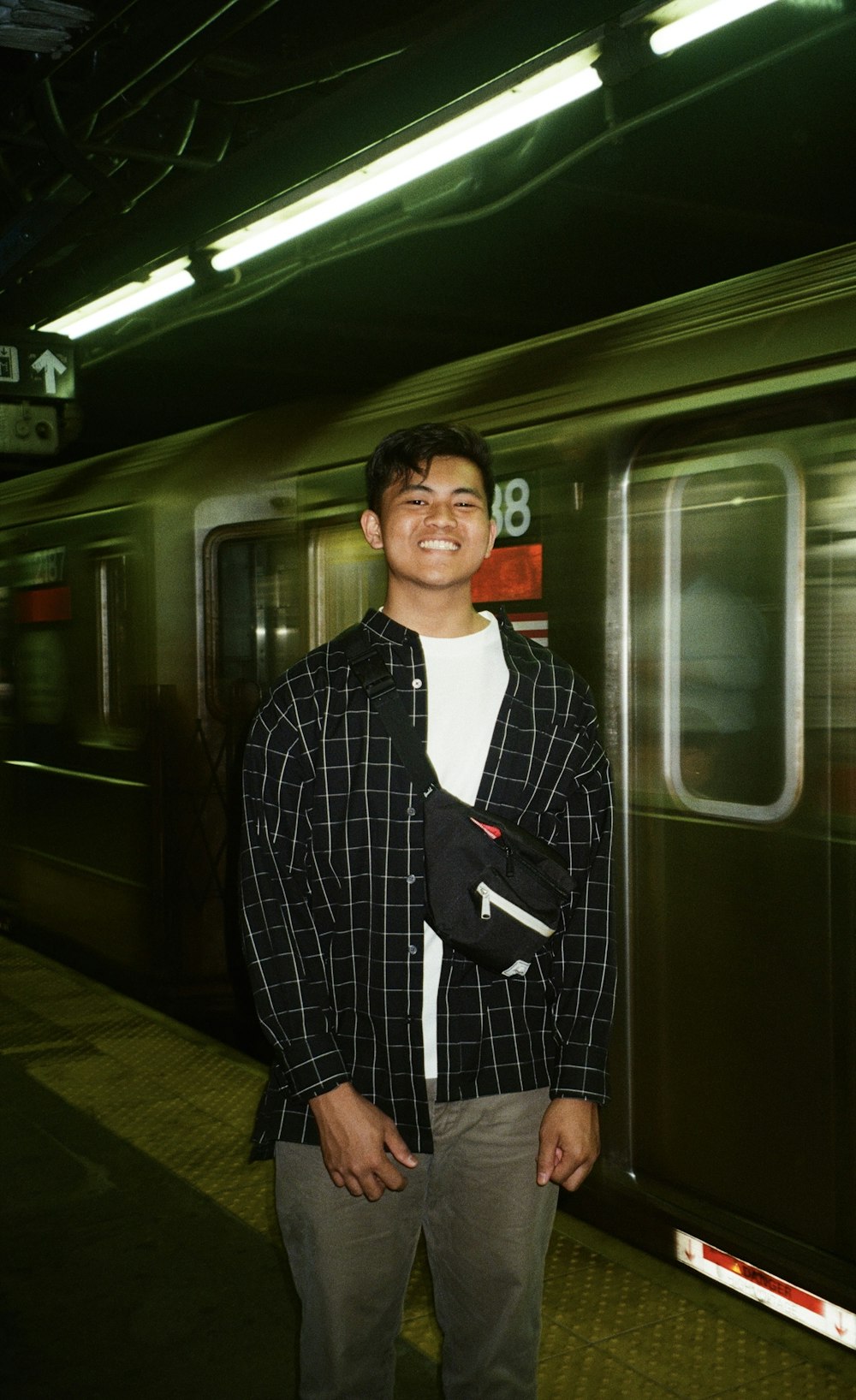 a man standing in front of a subway train