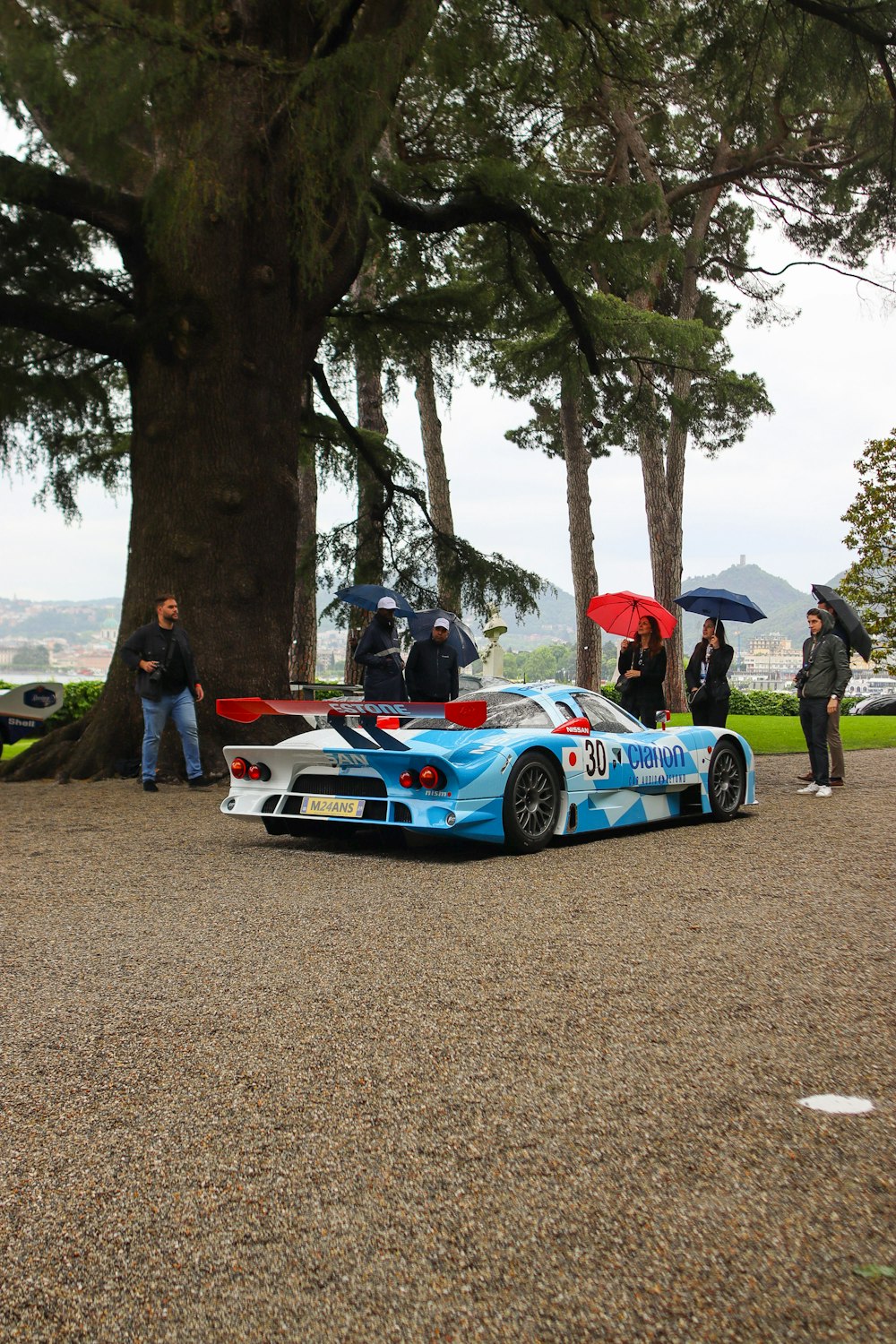 a race car parked in a parking lot next to a tree