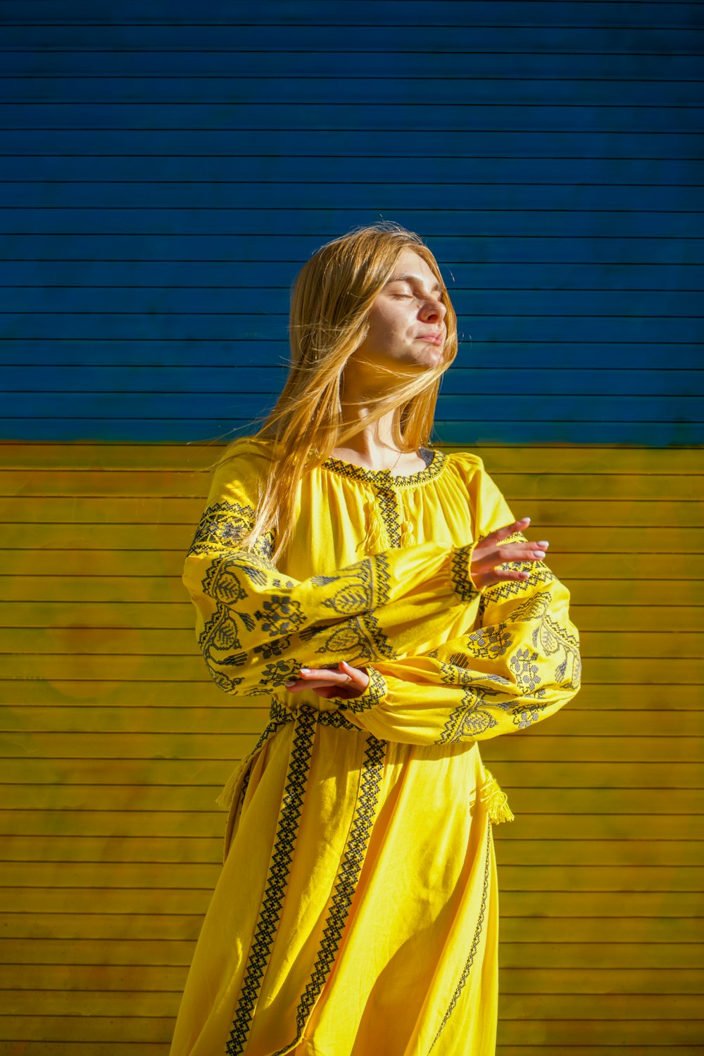 a woman in a yellow dress standing in front of a yellow wall