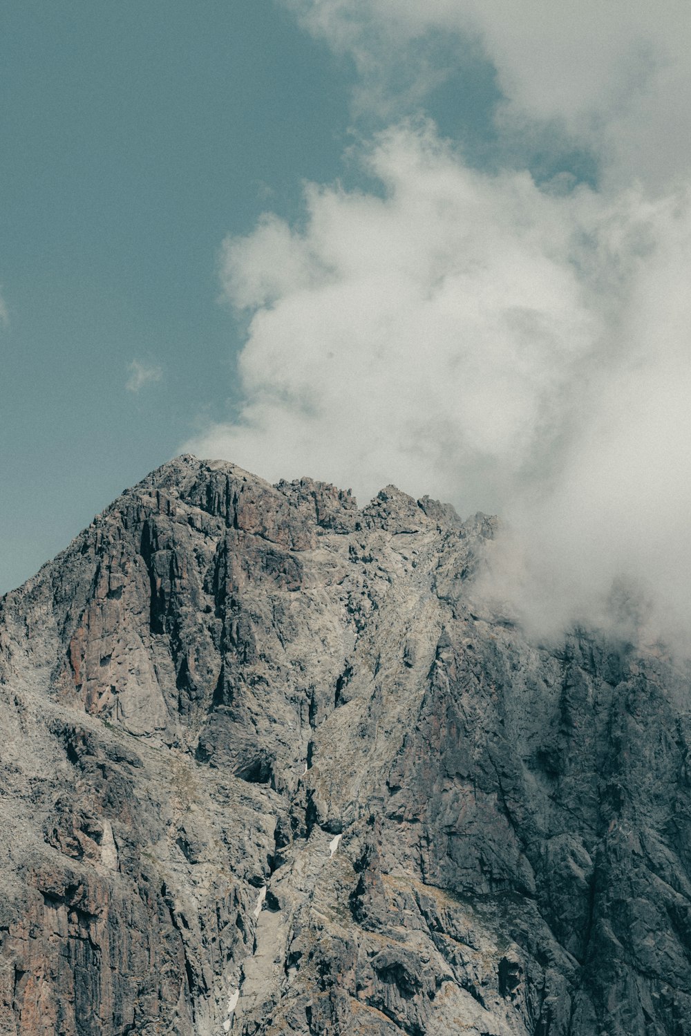 a very tall mountain with some clouds in the sky