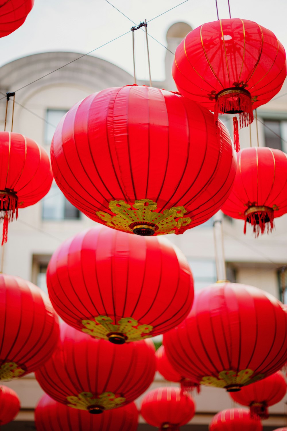 a bunch of red lanterns hanging in the air