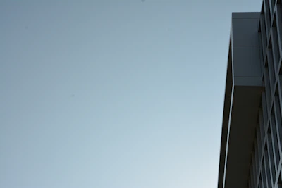 An elegant exterior shot of a minimalist building with clean lines and a blue sky backdrop.
