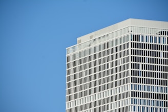 a plane flying in the sky over a tall building