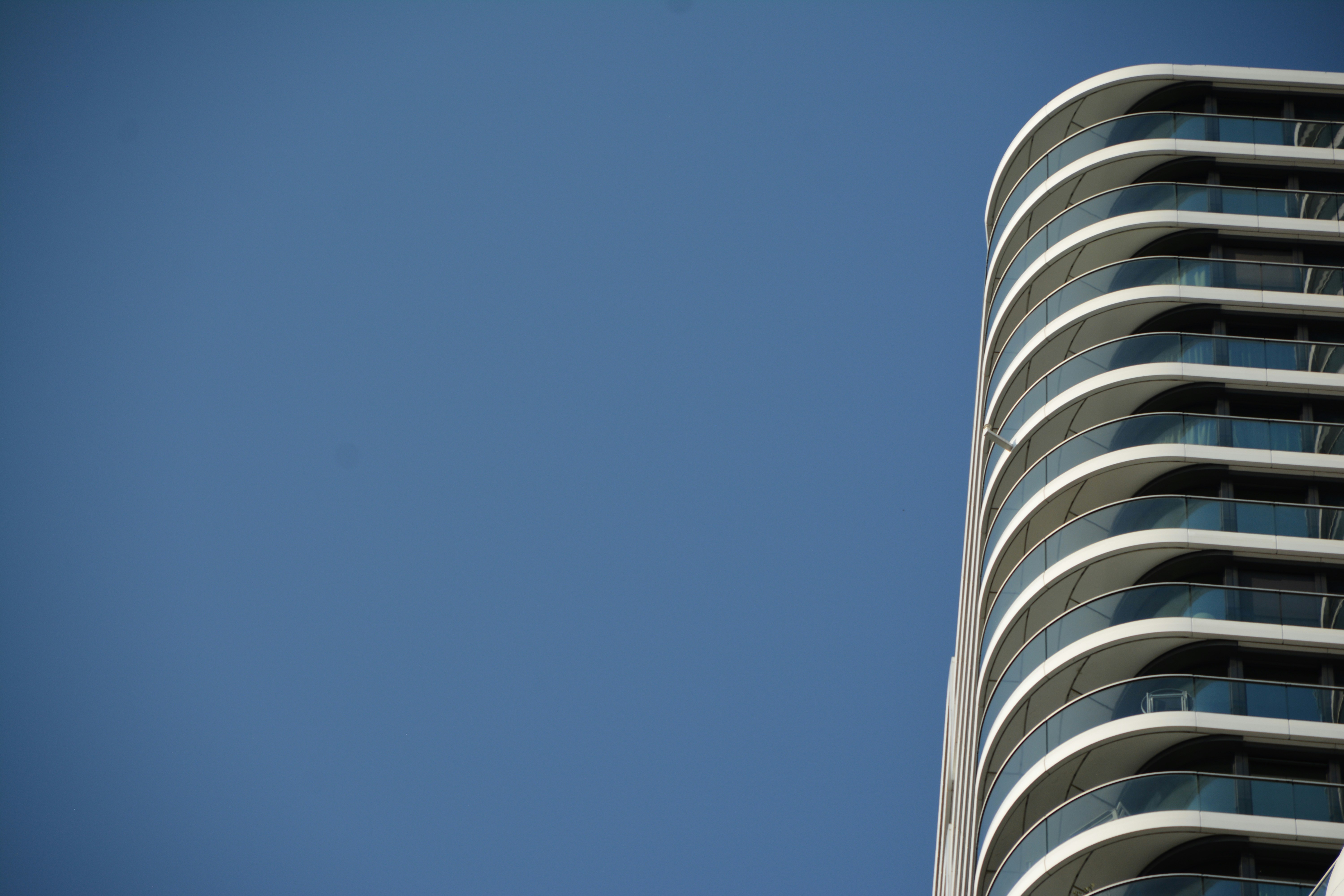 a tall building with balconies against a blue sky