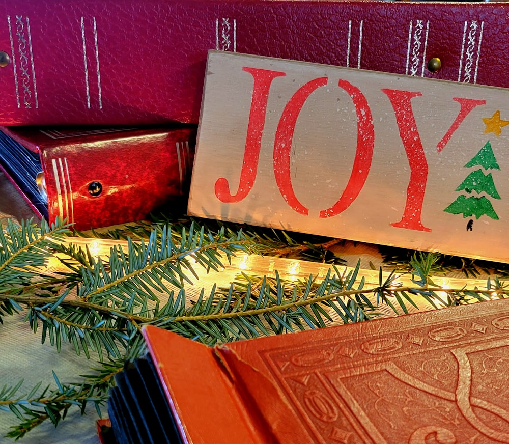 a wooden sign that says joy next to a christmas tree