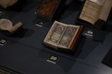 An open book with ancient texts and illustrations on a table.