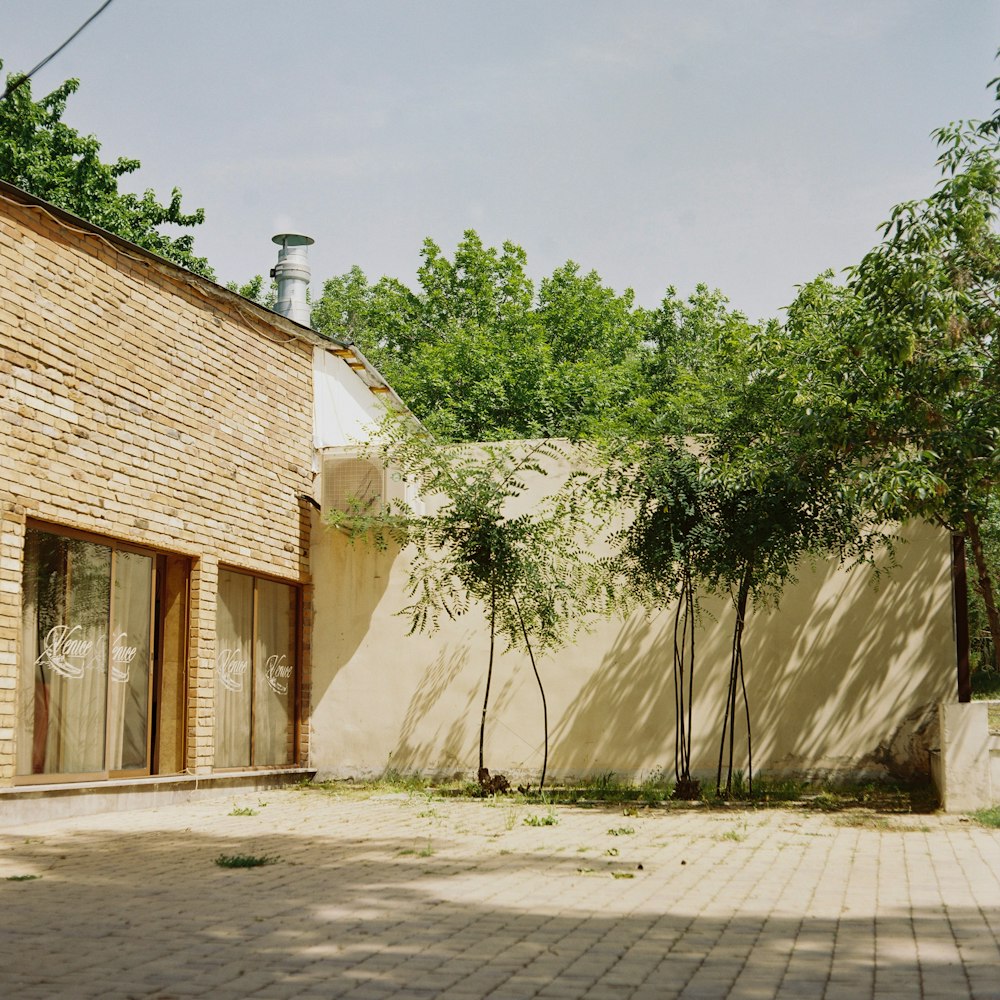 an empty courtyard with a brick wall and trees