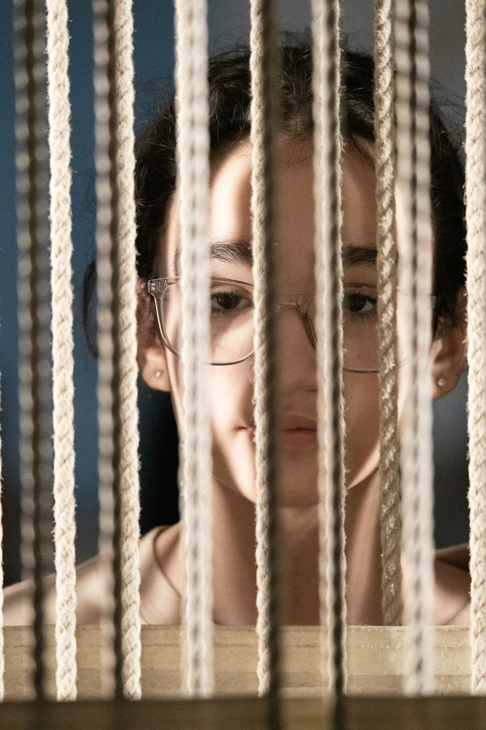 a woman looking through the bars of a jail cell