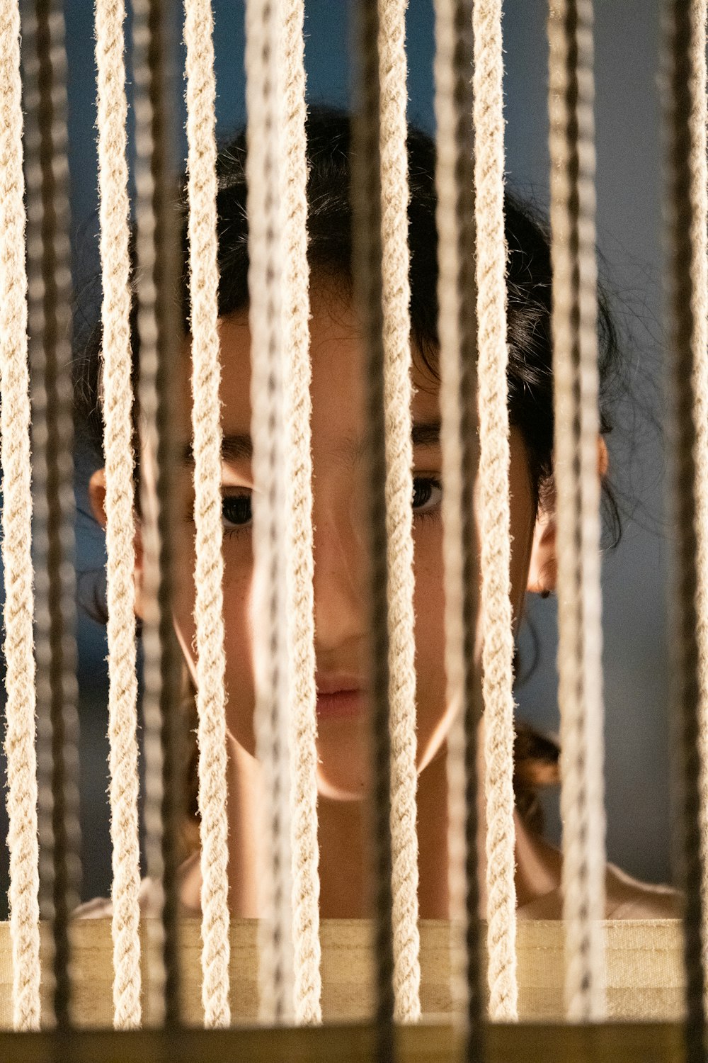 a woman looking through the bars of a jail cell