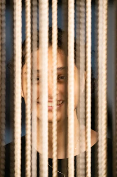 Friendly stringer demonstrating stringing techniques with a smile.