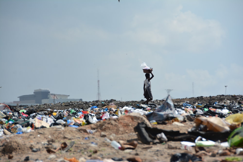 a man standing on top of a pile of trash