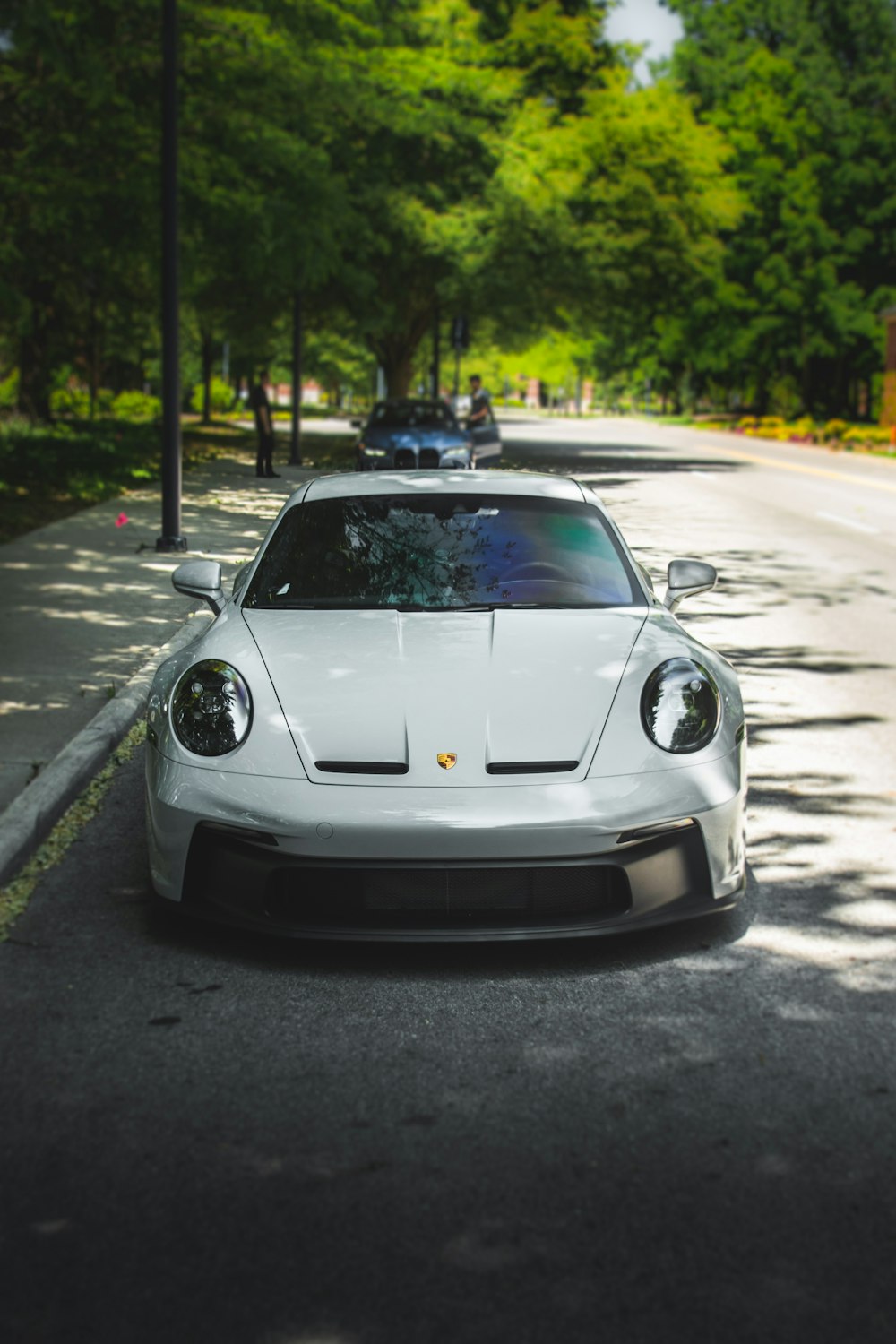 a white sports car parked on the side of the road