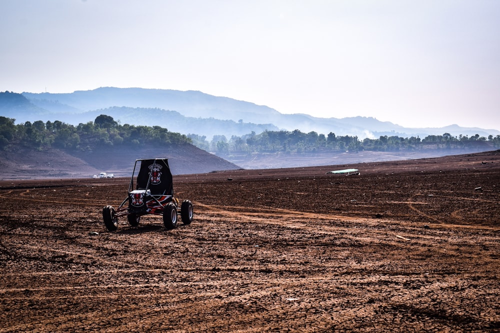 a buggy driving on a dirt road in the middle of a field