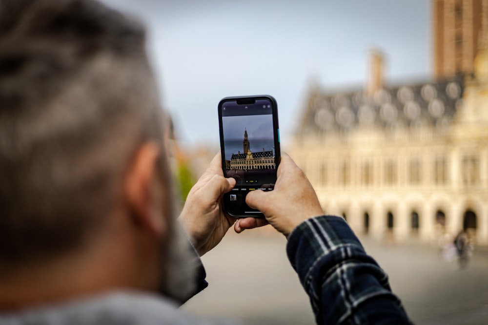 a person taking a picture of a building with a cell phone