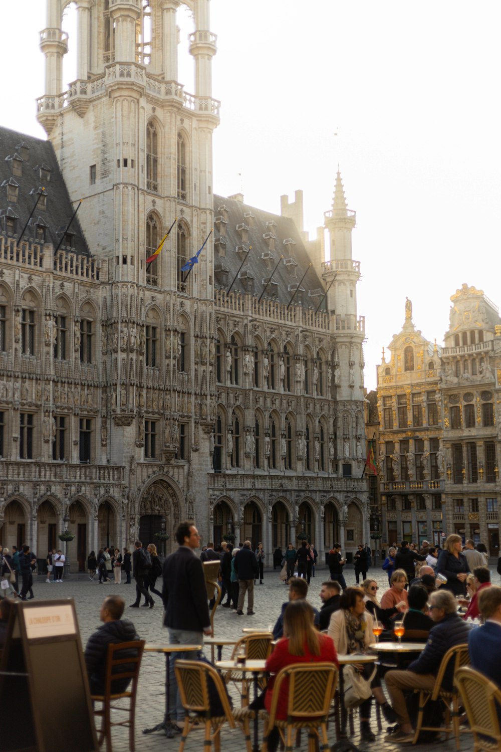 a group of people sitting at tables in front of a building