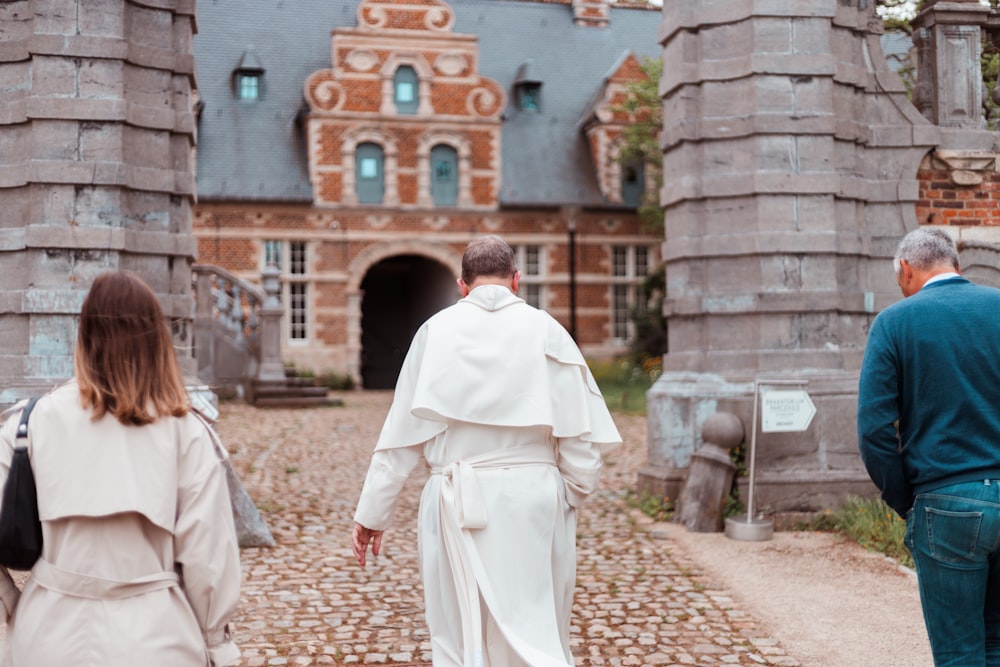 a group of people walking down a cobblestone road