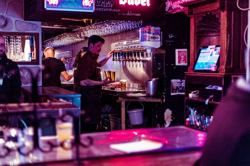 a man standing at a bar pouring a beer