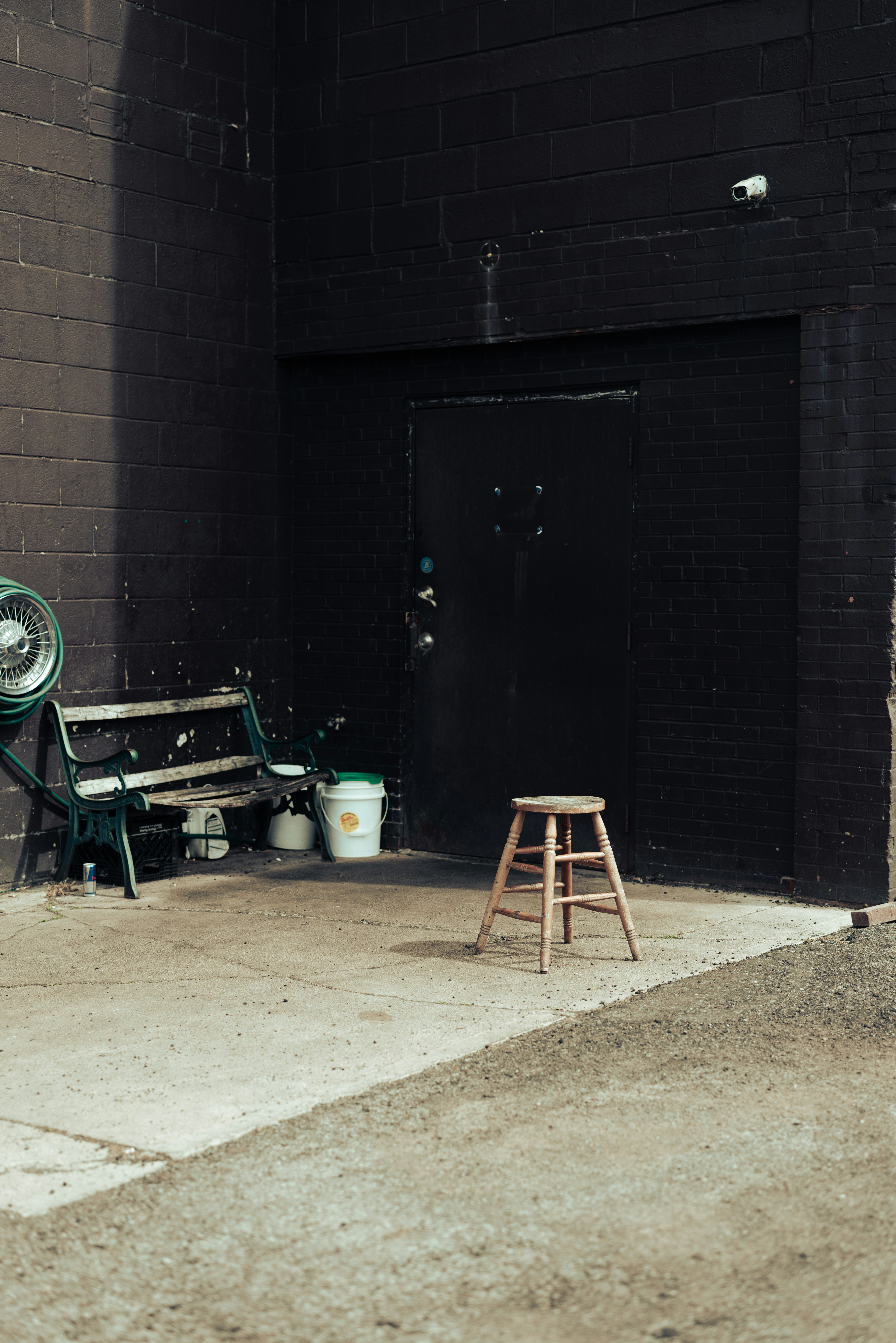 a wooden bench sitting next to a brick building