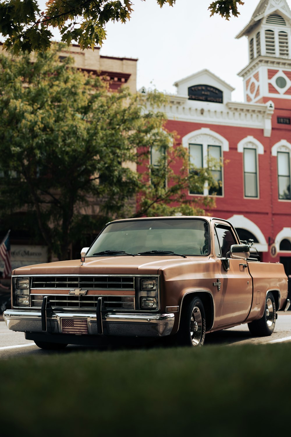 a brown truck parked in front of a red building