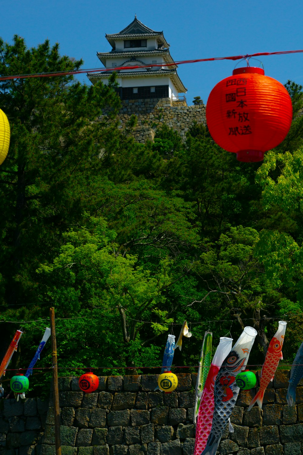 a stone wall with paper lanterns hanging from it