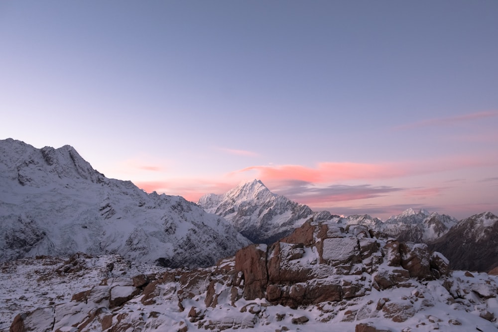 a snow covered mountain with a pink sky in the background