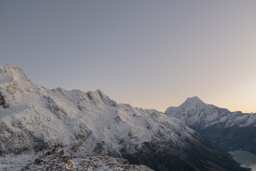 a snow covered mountain with a lake below